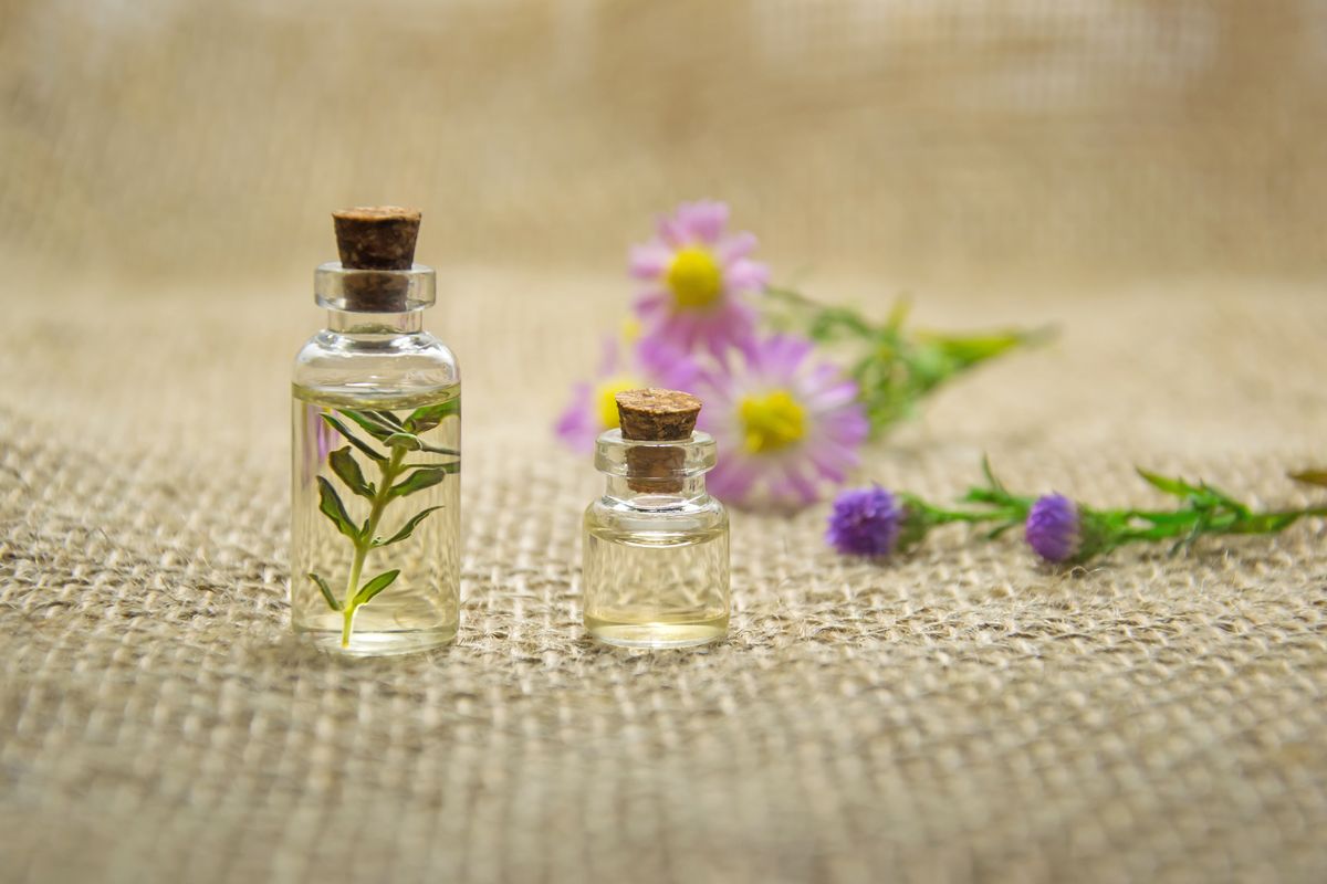 Illustration: What diseases can be treated with homeopathy — natural remedy bottles with flowers
